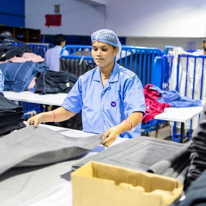 Operator checking finished garments at a quality control table